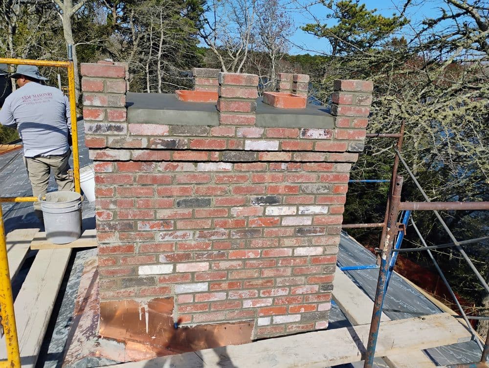 Brick chimney restoration showcasing detailed masonry and construction scaffolding.